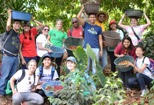 A group of GT students (men/women) during their trip to Guatemala. They're carrying baskets with coffee beans.