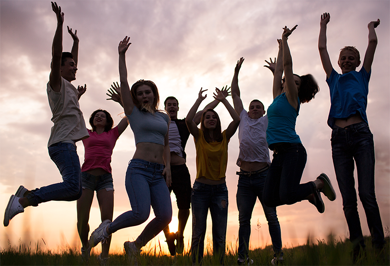 A group of young men and woman jumping.