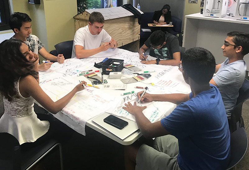 A group of young women and men students working on a project.