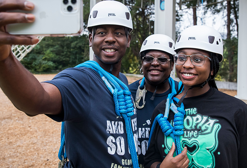 GT father, mother and daughter take a selfie on the GT challenge course.